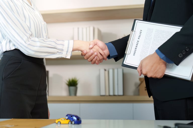 Agente de seguros y cliente estrechando manos después de finalizar un acuerdo, mostrando confianza y profesionalismo